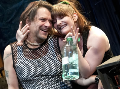 Toby on left with Maria holding a large Jim Beam bottle snuggling against his neck